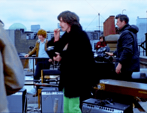 John Lennon And George Harrison Sharing A Cigarette During The Beatles’ Final Live Performance, 1969