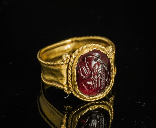 detournementsmineurs:Hellenistic ring in gold featuring a garnet intaglio of Apollo holding a lyre, 