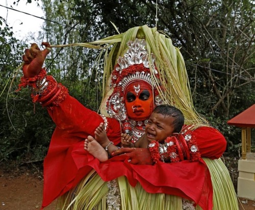 hinducosmos: A Theyyam dancer holding a child at Kannur, Kerala, India  Chirodeep Chaudhuri wrote:  