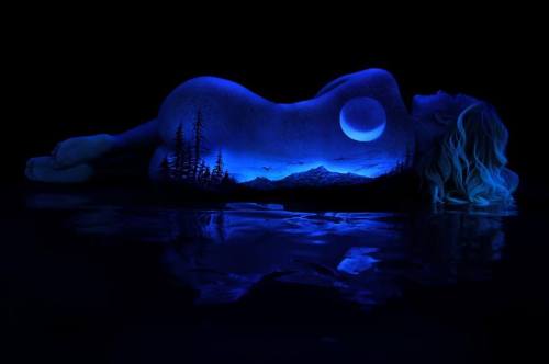 By John Poppleton. “The artist uses fluorescent pigment to paint landscapes on female models and pho