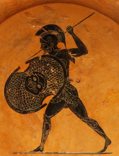 A warrior in armor, bearing a shield with a Gorgon’s head.  Detail of an Attic black-figure plate, a