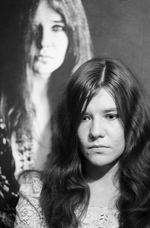 Janis posing in front of Bob Seiddmann poster, 1967.Photography by Baron Wolman.