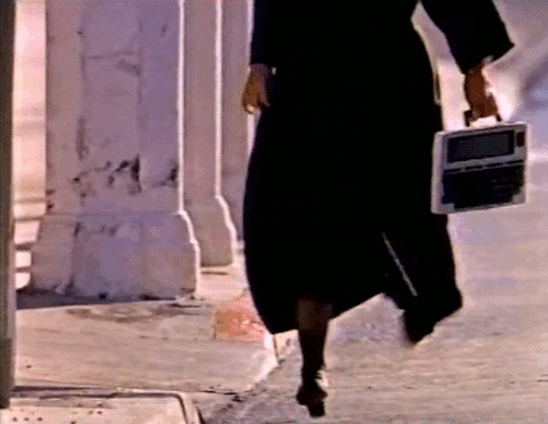 #dancing nun with early portable computer #1986#80s nuns#vhs#gif#80s tech#retrocomputing#crucifix#trs-80#model 100#kyocera#radio shack#tandy