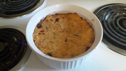 A round baking dish of somewhat browned salmon casserole. It still looks rather moist.