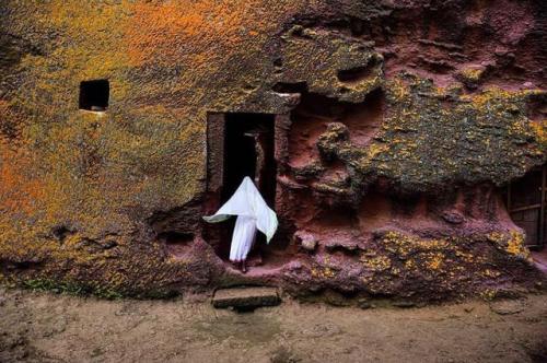 dolm:A woman enters an ancient medieval church that is carved into solid rock in Lalibela, Ethiopia.