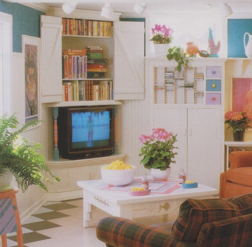 vintagehomecollection:An angled cupboard tucked into a corner of this basement family room stores th