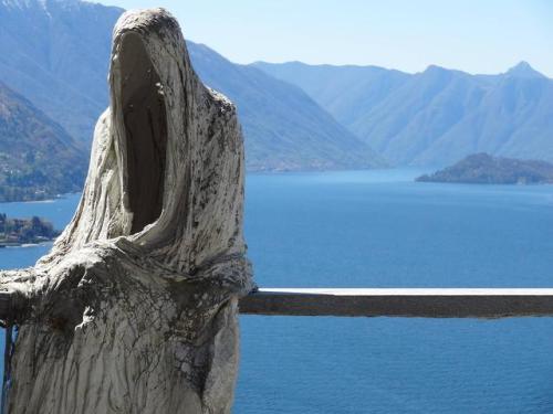 i-traveltheworld:An ominous figure sitting near the cliff-side at Lake Como, Italy.️❤️