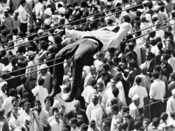 Sleeping Mourner at President Nasser&rsquo;s Funeral, Cairo, Egypt, 1970. As half amillion mourners gather in Ramses Square for the passing of President Nasser&rsquo;s cortege, one seeks lebensraum by edging along tram powerlines above their heads.