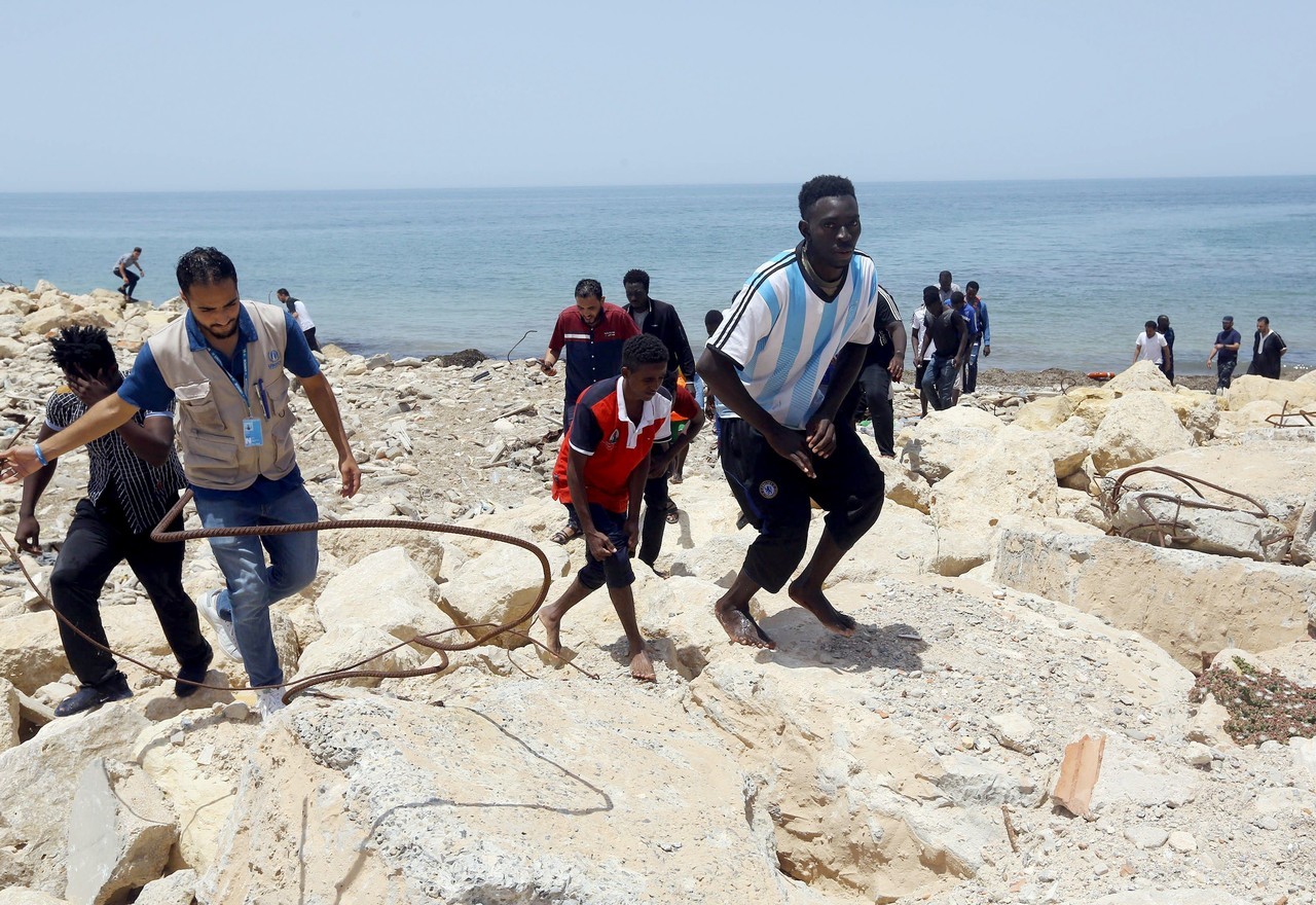 NAUFRAGIO. Miembros de las fuerzas de seguridad libias transportan los cadáveres de bebés mientras los migrantes que sobrevivieron al hundimiento de un bote inflable frente a las costas de Libia son llevados a tierra en al-Hmidiya, al este de la...