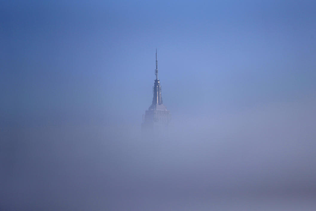 The tip of the Empire State Building peeks through a thick fog in this view from Hoboken, N.J. (Photo by Julio Cortez/AP via Yahoo News)
