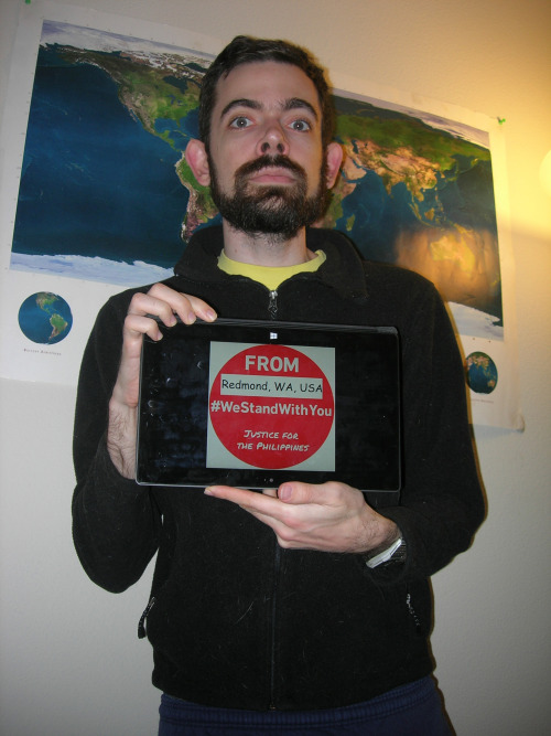 Benjamin Sibelman with a picture of a red dot on a Surface tablet, and a poster of Earth