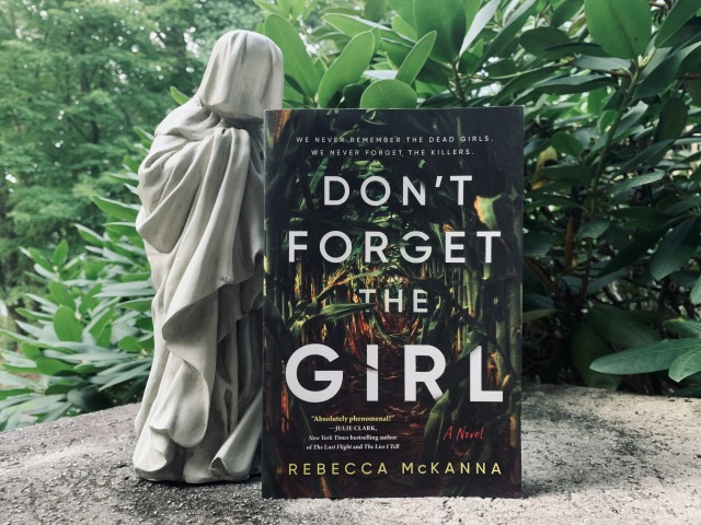 Shown is DON'T FORGET THE GIRL (with cover art depicting a corn field) against a backdrop of greenery, with a veiled weeper or pleurant beside the book. Photo by AHS.