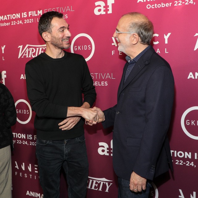 director Patrick Imbert shakes hands with festival founder and GKIDs CEO Eric Beckman on the festival red carpet 