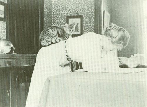 Edith Holman Hunt, wife of Pre-Raphaelite artist William Holman Hunt, with a cat on her back. 