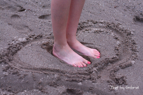 Pretty feet in sandals and sand.