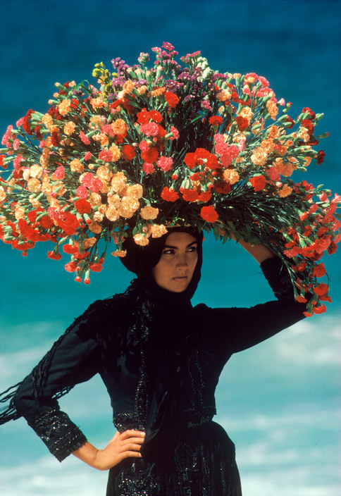 fotojournalismus:A woman strolls the beach at Nazaré, Portugal, 1985.Photo by Bruno Barbey