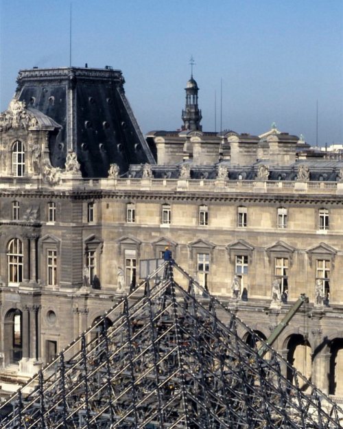 Un ouvrier hisse une pièce d’étoffe au faîte de la Pyramide du Louvre en construction  #sergesautere