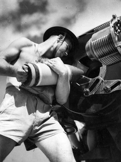 Australian soldier loading an artillery piece, World War II.