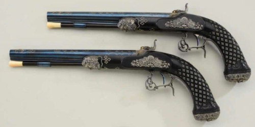 An ornately engraved gold and silver decorated set of dueling pistols crafted by Andreas Kuchenreute