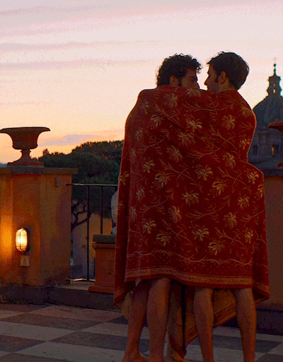 Andrea Di Luigi as Pietro & Damiano Gavino as Enea, both snuggled under a blanket, kiss in embrace on a rooftop with sweeping views of the roman city skyline at sunrise.

Nuovo Olimpo (2023) · Romance · dir. Ferzan Özpetek

 · [Gif Creator/Editor: k-wame.tumblr.com]

