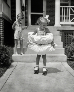 Equipped with bumpers fore and aft, 4-year-old Betty Buck is taking no unnecessary chances as she tries her first pair of roller skates, 1936.