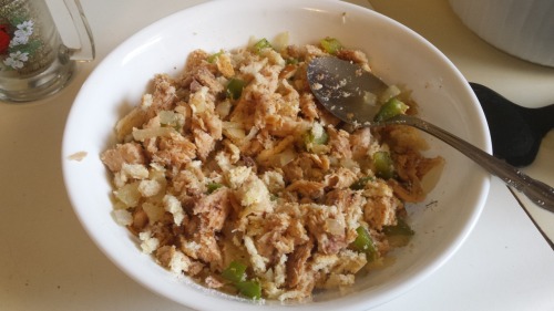A white bowl with a mixture of bread crumbs, onion, and green peppers