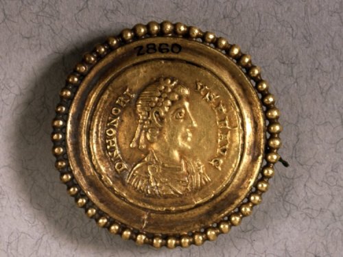 Gold brooch made from a gold solidus of Honorius. Obverse has a bust of Honorius, diademed, draped a