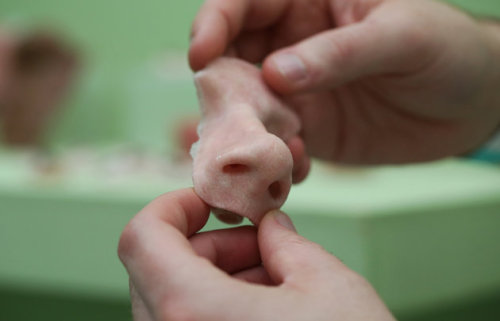 yaongyaong:  sixpenceee:  A funeral home in Shanghai is 3D printing body parts for corpses. Above, a visitor holds a 3D printed prosthetic nose during the 3-D Print show at the Business Design Center in London on Friday, Nov. 8, 2013. (Source)  this is