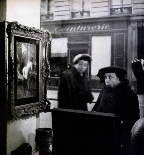yesterdaysprint:In Romi’s antique shop on the Left Bank, Paris, photographer Robert Doisneau set up 