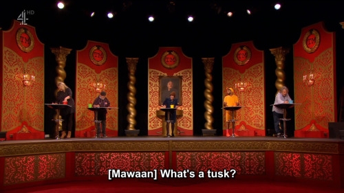 [ID: Five screencaps from Taskmaster. The five contestants stand in a row on the studio stage, each 