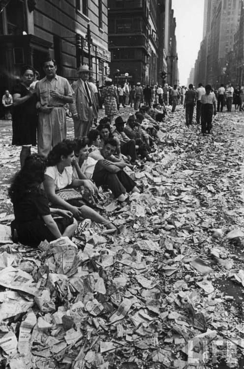 historyinpics42:  People sitting on curb among confetti and paper after celebrating