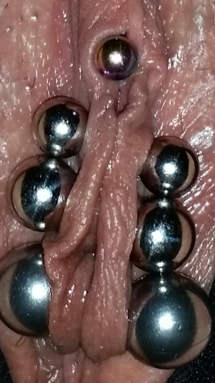 pussymodsgaloreReferring only to the bottom picture (this is Pussy Mods Galore!), she has six piercings in her inner labia, joined and closed by heavy gauge barbells. Looks most impressive. Chastity piercing. Additionally she has a VCH piercing with a