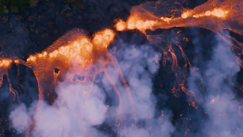 fuckyeahfluiddynamics: Kilauea continues to erupt without signs of abating. Aerial video, like this footage from Mick Kalber, shows the scope of the flow. Lava spurts like a hellish fountain from various fissures, then forms a gravity current that slowly