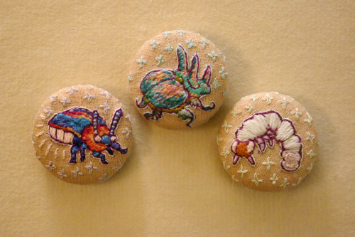 hand embroidered one-of-a-kind glowy bug pins! each one inch