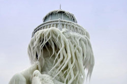 awkwardsituationist:  photos by thomas zakowski at the st. joseph north pier on the coast of lake michigan, where crashing winter waves have covered two lighthouses and the connecting bridge in ice.