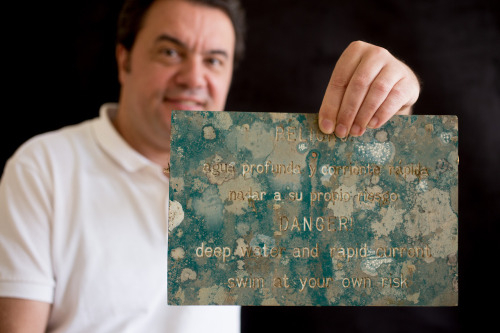 Robert Lücking - Collections Manager and Adjunct Curator, Botany, holding a plastic sign covered with lichens collected in a rain forest in Costa Rica.