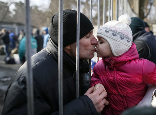 A girl kisses her father, a conscript, after a ceremony marking enrollment for new conscripts in the