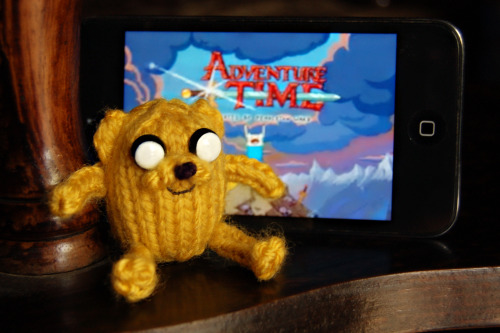 superslyskillzmcfly:  I just finished my first knitting pattern! It’s incredibly simple but I’m still pretty proud of it.  Pocket Jake! Adventure Time fans might remember the episode where Jake was mysteriously absent until the very end when he