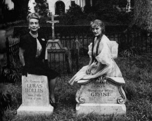 The Epic That Never Was: JOAN CRAWFORD and BETTE DAVIS astride fake tombstones in a publicity shot f