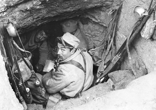 scrapironflotilla: French troops in a small dugout, one of whom is writing a letter, April 1916.