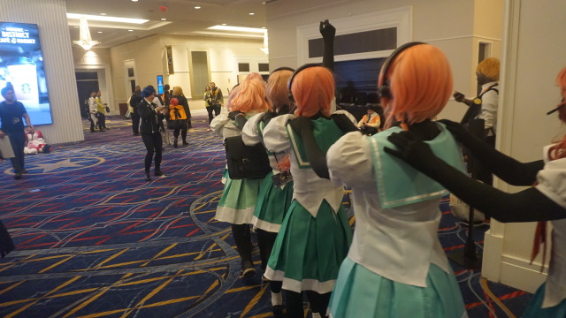 It's 8PM. It's a long first day at the con. Then suddenly, a conga line of the Shadow Girls from Utena start walking by in 