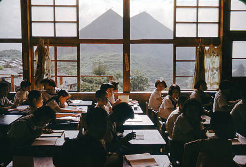 s-h-o-w-a:Students study at a classroom while spoil banks are seen on the background at a coal mine 