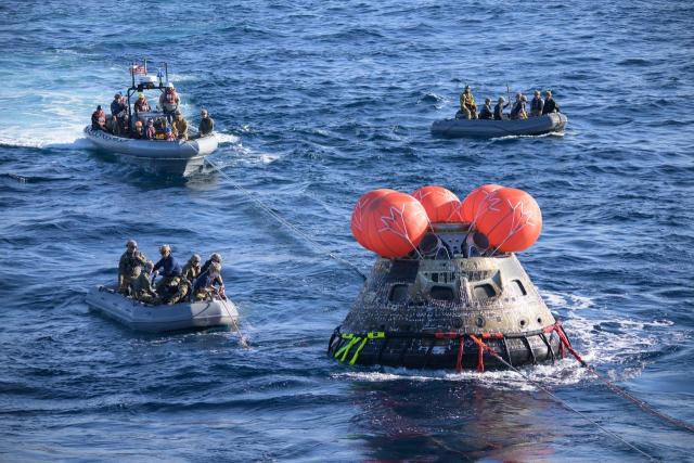 After splashing down at 12:40 p.m. EST on Dec. 11, 2022, U.S. Navy divers help recover the Orion Spacecraft for the Artemis I mission. NASA, the Navy and other Department of Defense partners worked together to secure the spacecraft inside the well deck of USS Portland approximately five hours after Orion splashed down in the Pacific Ocean off the coast of California. Credit: NASA/Josh Valcarcel