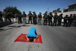 don-moh:  A Palestinian boy defies the Israeli forces on friday after they prevented him from praying in Al-Aqsa Mosque so he prayed in front of them on the asphalt. طفل فلسطيني يغيظ جنود الإحتلال ويصلي أمامهم على