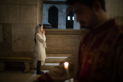 An Armenian woman prays at the Church of the Holy Sepulchre for the Sunday morning mass in Jerusalem