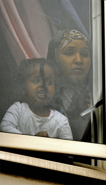 ihatethismess:
“ “A mother and daughter look out of the window as they watch anti muslim protestors being arrested by the police in Harrow, North London on September 11, 2009. Riot police intervened to quell clashes between Muslims and anti-Islamic...