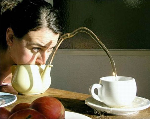 tea pot and tea cup trick - girl blows tea into cup