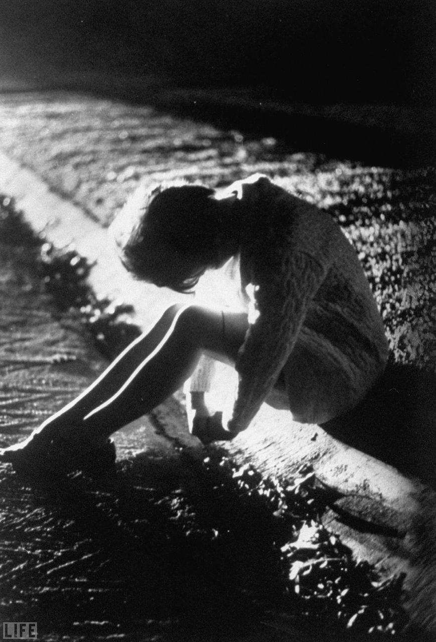 Mrs. Donn F. Eisele sitting on the side of the road during her husband&rsquo;s