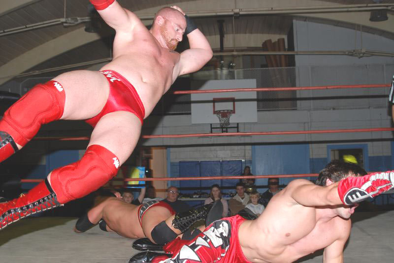 the dude in the red pants has had enough, he wants to tag his partner up. but the shaved head red beard dude has something else in mind. he’s a man’s man, all big and burly, he drops a flying elbow drop right on the dude crawling to make the tag. he...