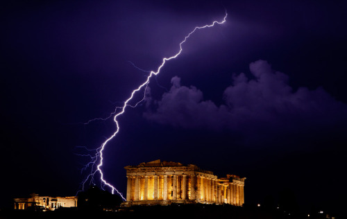 A flash of lightning illuminates the sky over the 2,500-year-old Ancient Parthenon temple, at the Ac